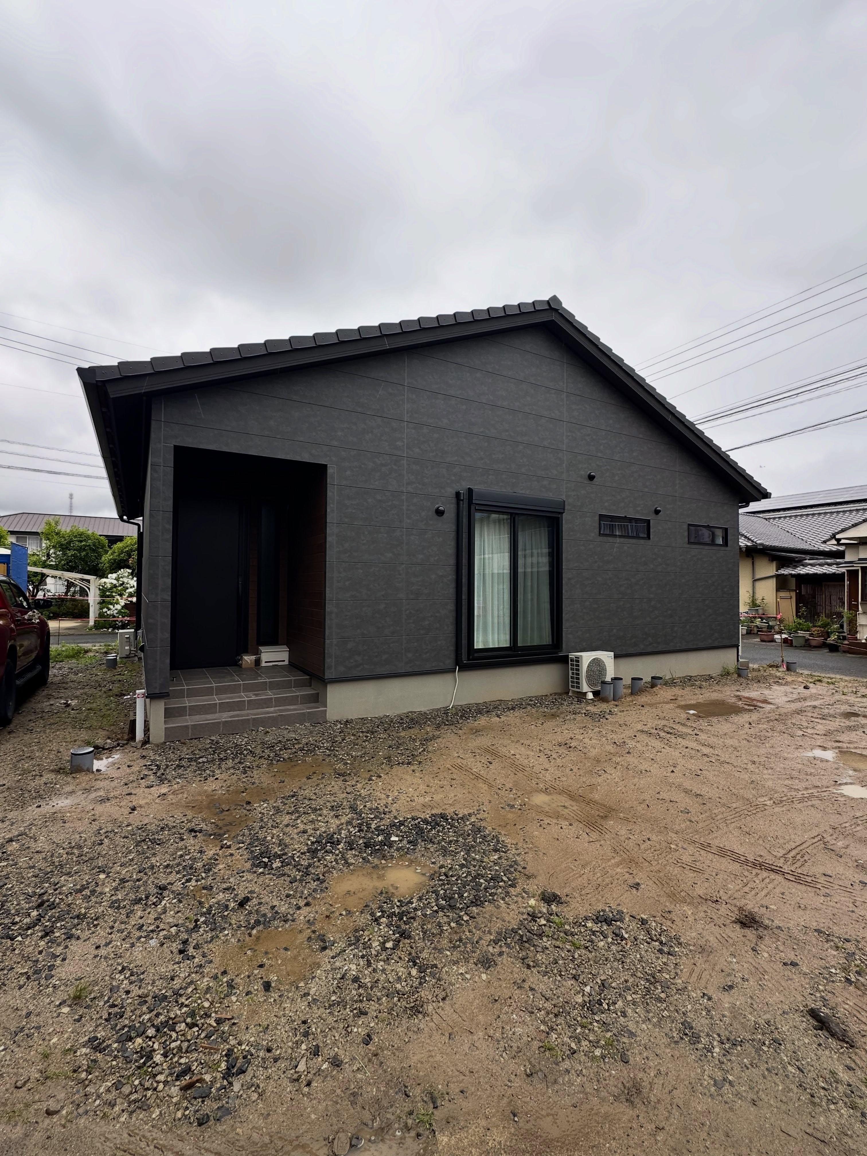 外構施工前の、土と砂利が広がる住宅前の敷地